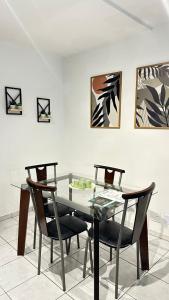 a dining room with a glass table and chairs at Loft Studio Central in Nova Friburgo
