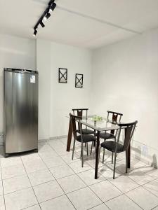 a dining room with a table and chairs and a refrigerator at Loft Studio Central in Nova Friburgo +4 photos