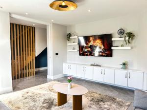 a living room with a fireplace and a tv on the wall at Central Haven Dingle in Dingle