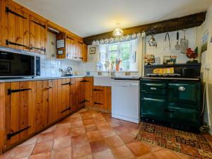 a kitchen with wooden cabinets and a black and white appliance at 2 Bed in Lechlade oc-40194 in Langford