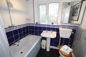 a blue tiled bathroom with a sink and a bath tub at 3 Bed in Mumbles oc-hh19 in The Mumbles