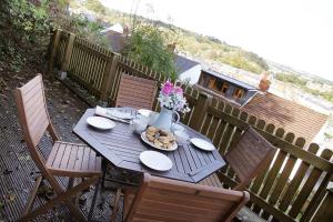 a wooden table with plates of food on a patio at 3 Bed in Mumbles oc-hh19 in The Mumbles