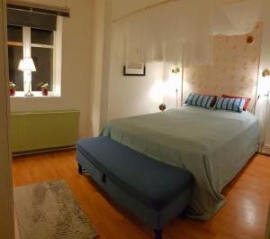 a bedroom with a large bed with a blue ottoman at Parkvillan Sunshine Living Condo in Koppom