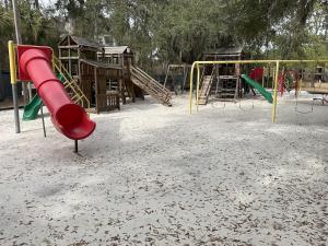 a playground with a red slide in the sand at Beach Skybox HHI in Hilton Head Island