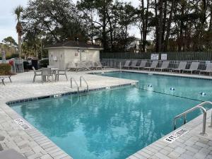 a large swimming pool with chairs and a table at Beach Skybox HHI in Hilton Head Island