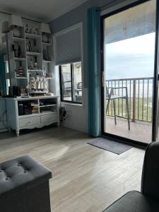 a living room with a large sliding glass door with a balcony at Beach Skybox HHI in Hilton Head Island