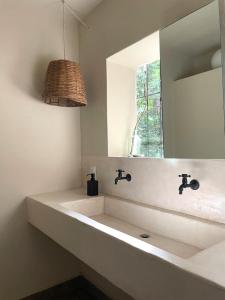 a bathroom with a sink and a mirror at Villas Ecotucan in Bacalar