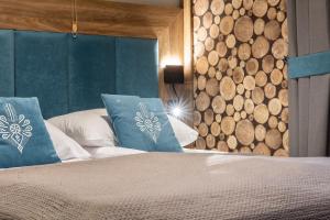 a bedroom with a bed with blue pillows at Czerwone Wierchy Premium Apartment in Zakopane