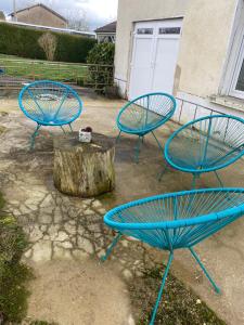 three blue chairs and a table in a yard at Au petit charmeur! in Sorbey