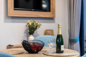 a bottle of wine and two glasses on a table at Czerwone Wierchy Premium Apartment in Zakopane +4 photos