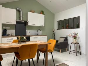 a kitchen and dining room with a wooden table and chairs at Au petit charmeur! in Sorbey
