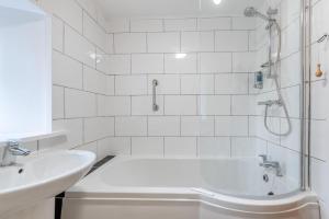 a white bathroom with a tub and a sink at 1 Bed in Drefach oc-m30848 in Llanwenog +17 photos