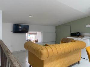a living room with a couch and a kitchen at Au petit charmeur! in Sorbey