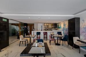 a restaurant with tables and chairs and a bar at Isaaya Hotel Boutique by WTC in Mexico City