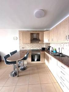 a kitchen with a table and some chairs in it at LANI house - stunning pool in Palm-Mar