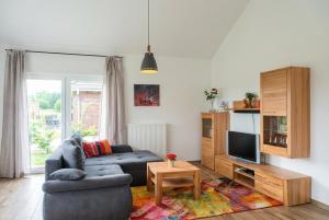 a living room with a couch and a tv at Haus Dornröschen in Schweiburg