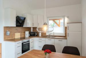 a kitchen with white cabinets and a table and a window at Haus Dornröschen in Schweiburg