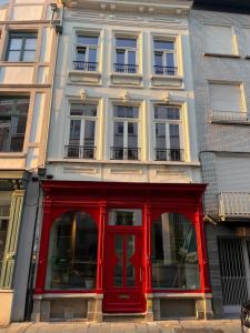 ein Gebäude mit einer roten Tür davor in der Unterkunft Kaffee Changé in Gent