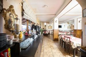 a restaurant with a counter and a dining room at Pensiunea Andreea in Baia de Fier