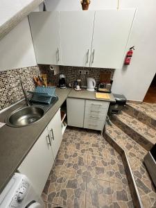 a kitchen with white cabinets and a sink at 2 bed room apartment , sea view, 10 minutes walk to the beach in Ribeira Brava +15 photos