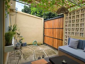 a small patio with a fence and a blue couch at Rumah Risa in Tanah Lot