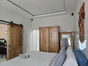 a bedroom with a bed and a wooden cabinet at Rumah Risa in Tanah Lot