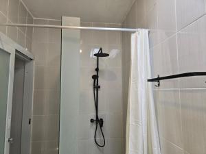 a shower in a bathroom with a shower curtain at Rumah Risa in Tanah Lot +5 photos