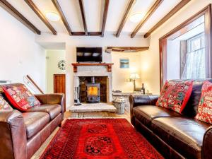 a living room with leather couches and a fireplace at 2 Bed in Matlock oc-81043 in Winster