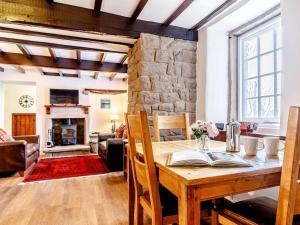 a dining room with a table and a stone wall at 2 Bed in Matlock oc-81043 in Winster