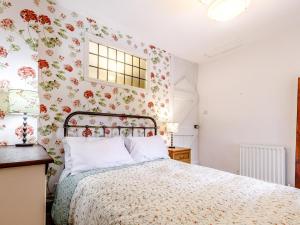 a bedroom with a bed with floral wallpaper at 2 Bed in Matlock oc-81043 in Winster