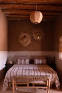 a bedroom with a bed with two pillows at Muma Lodge in Bouihat