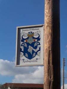 a sign on a wooden pole next to a building at Lantana Stone House in Lemona