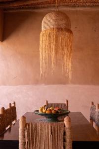 a table with a plate of food and a chandelier at Muma Lodge in Bouihat