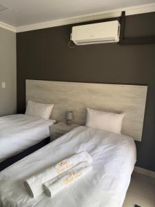 a bedroom with two beds with towels on them at M & N Guest House in Ermelo +37 photos