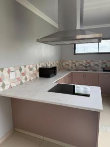 a kitchen with a white counter top with a sink at M & N Guest House in Ermelo