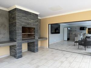 a living room with a fireplace and a dining room at M & N Guest House in Ermelo
