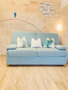 a blue couch with pillows on it in a room at Antigua in Monopoli