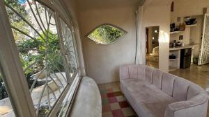 a living room with a couch and a window at Calle Ouvert in Mérida