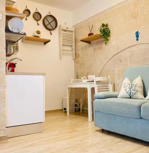 a living room with a blue couch and a table at Antigua in Monopoli