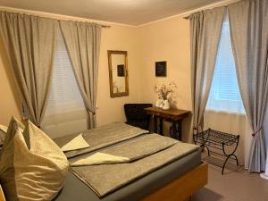 a bedroom with a bed and a chair and windows at Ferienhaus Tolazzi in Arnoldstein