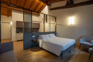 a bedroom with a bed and a chair in a room at Ca Moroni Collection in Bergamo