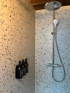 ein Badezimmer mit Dusche, an dessen Wand drei Flaschen stehen in der Unterkunft Kaffee Changé in Gent + 31 Fotos