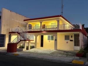 a yellow house with a staircase in front of it at Fontana Sunset - Spacious 3BR Family Home in Carolina