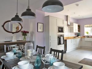 a dining room with a table with chairs and a kitchen at 3 Bed in Bakewell oc-90384 in Bakewell