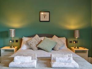 a bedroom with a bed with two lamps and two chairs at 3 Bed in Bakewell oc-90384 in Bakewell +20 photos