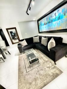 a living room with a black couch and a tv at Apartamento Premier in Ibagué
