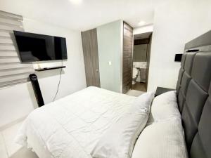 a bedroom with a bed and a flat screen tv at Apartamento Premier in Ibagué