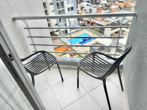 a chair on a balcony with a view at Apartamento Premier in Ibagué +8 photos