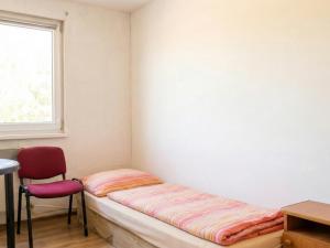 a bed in a room with a chair and a window at Kechnec - Seňa in Kehnec