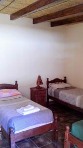 a room with two beds in a room with wooden ceilings at MiskyPacha in Purmamarca